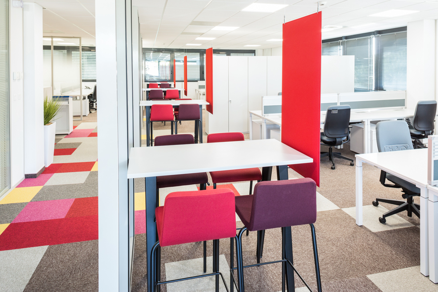 Plusieurs petits espaces de co-working avec la décoration à dominante rouge