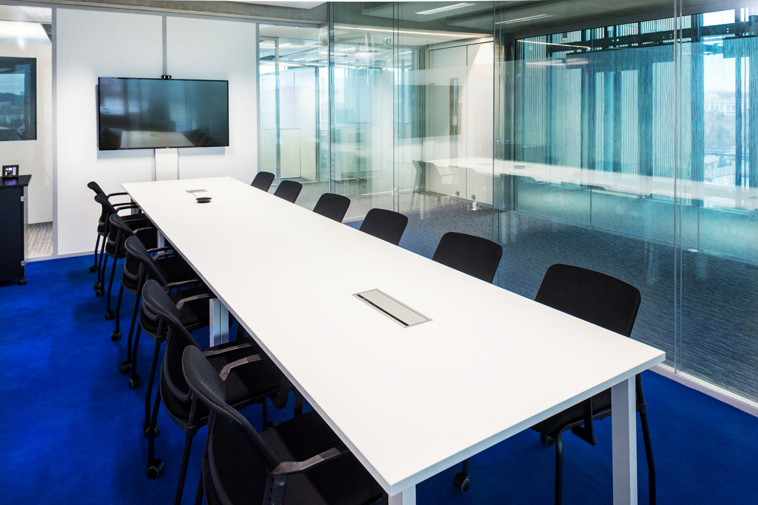 Grande table dans une salle de réunion avec une moquette bleu