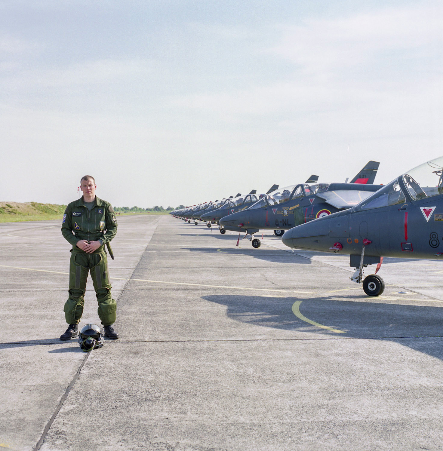 Pilote militaire devant un alignement d'avions Alphajet