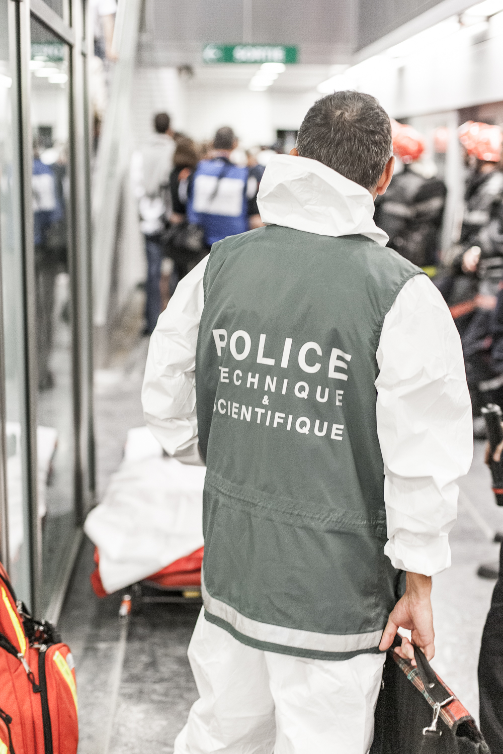 Un policier technique et scientifique de dos, avec un gilet, participe à l'exercice plan rouge dans une station du métro de Toulouse