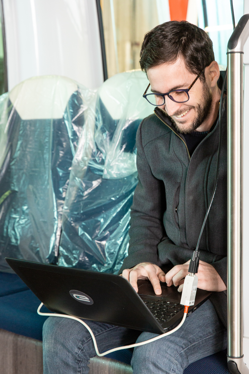 Un employé programme le logiciel du véhicule Easymile depuis son ordinateur portable. Il est assis dans le véhicule.