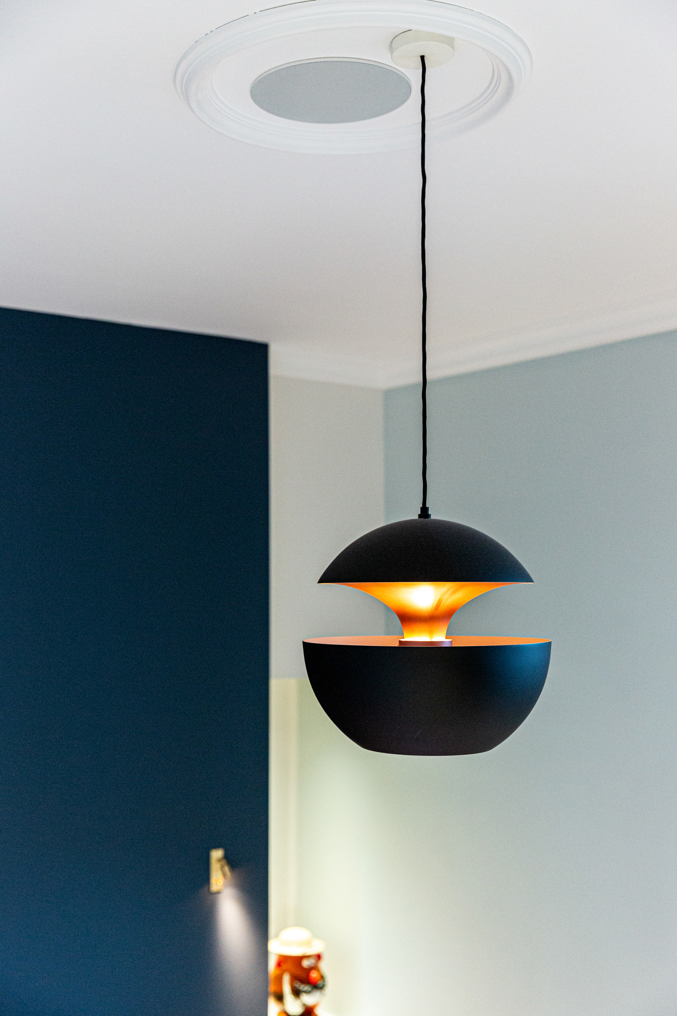 Lampe ronde bleue foncée, dans une chambre. Photographie design et décoration.