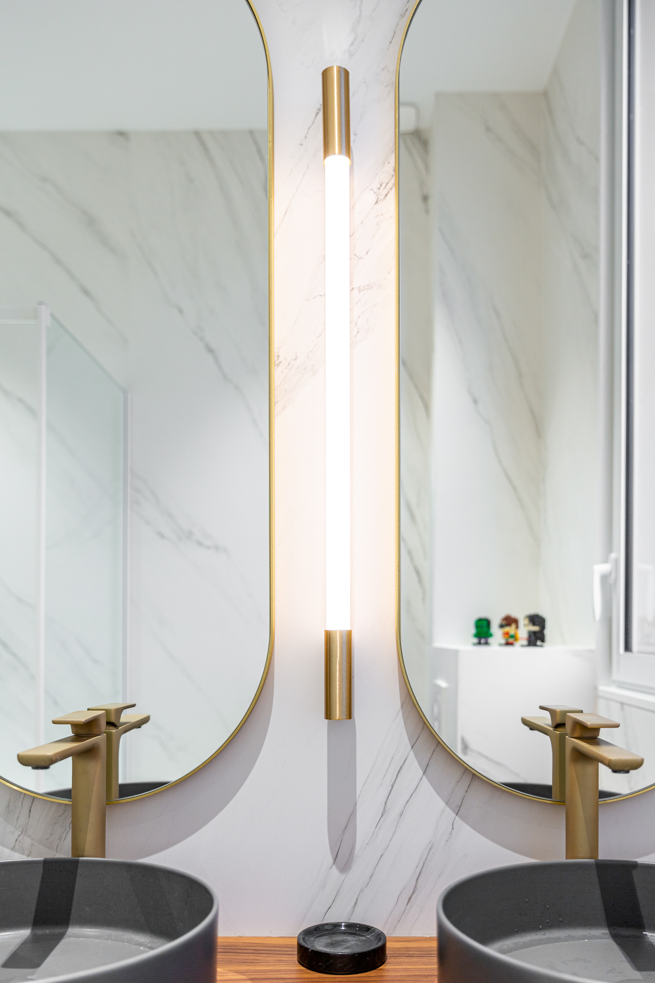 Eclairage de type tube dans une salle de bain avec deux miroirs. On aperçoit deux vasques