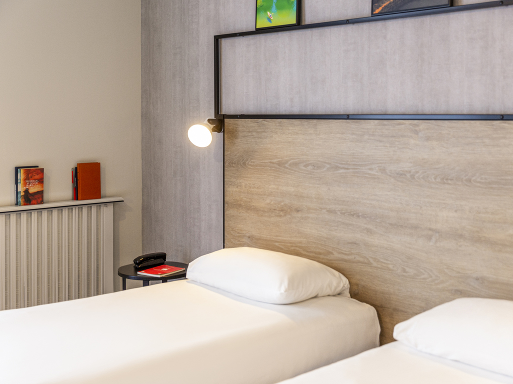 Photographie d'une chambre d'hôtel avec deux lits simples