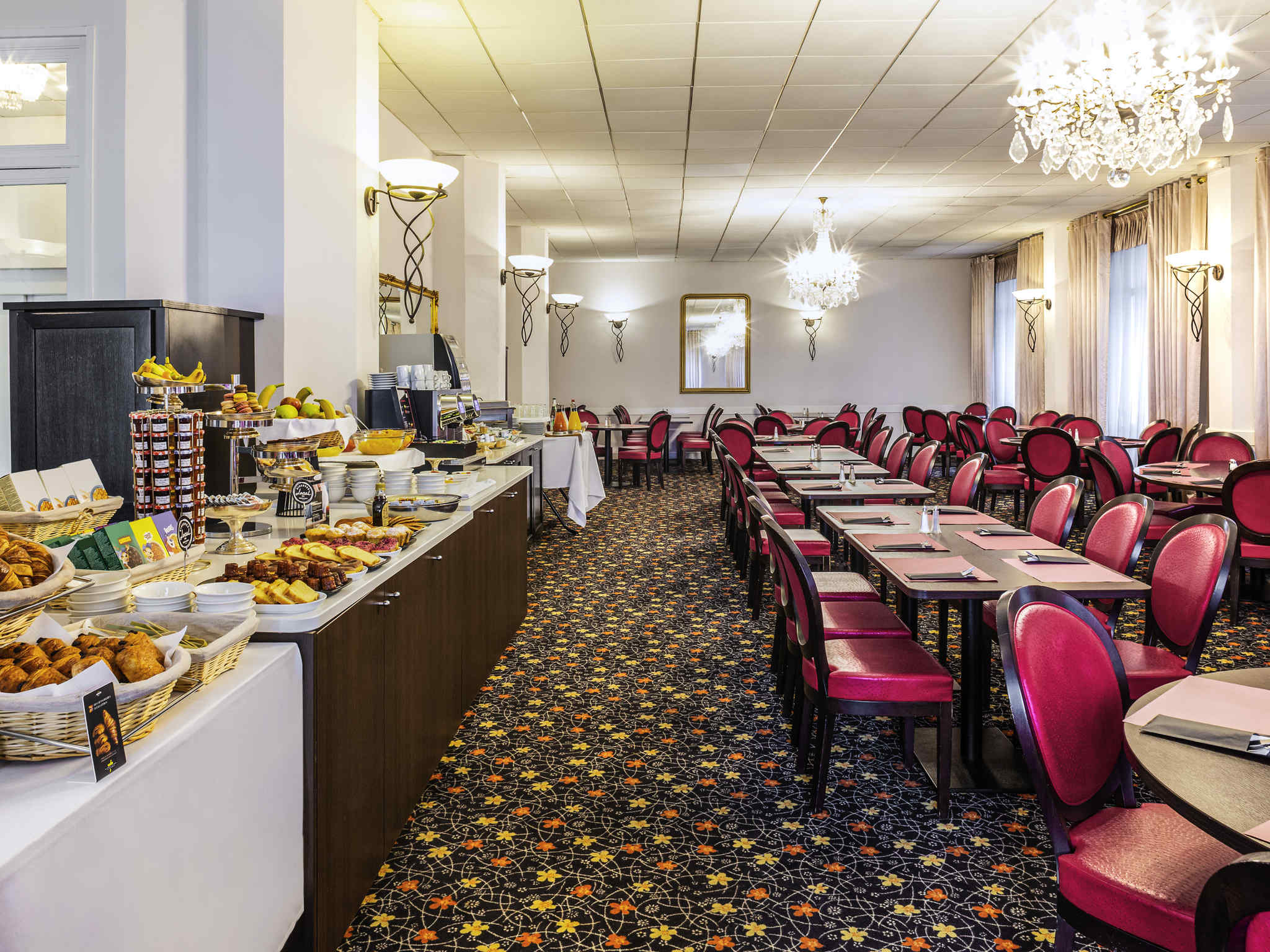 Photo descriptive de la zone de restaurant, avec les tables et les chaises, et le buffet de petit déjeuner.